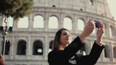 Genç güzel kadın selfie smartphone alır. Roma, İtalya Colosseum yakınındaki yürüyen kadın.
