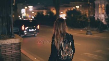 Gece geç saatlerde yürüyüş sırt çantası ile esmer kadın. Akşam şehir merkezine yakın yol çekici kız geçer.