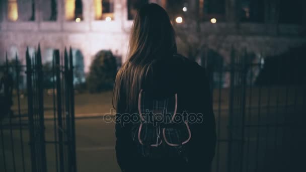 Fiatal barna nő jön, földszinti, szemben a Colosseum, Róma, Olaszország. Lány séta a városban, késő este.