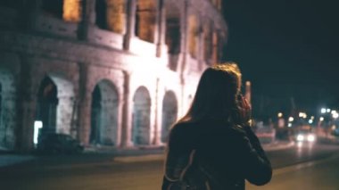 Roma, İtalya Colosseum yakınındaki ayakta ve smartphone kullanarak çekici kadın. Yürüyüş ve telefonda konuşurken kız.