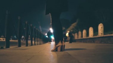 Yakın çekim görünümü kadın bacak üzerinde yüksek topuk ayakkabı giyiyor. Akşam ve bekleyen köprüde duran kadın.