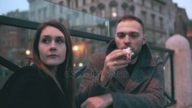 Oturan genç kadın dışında adam gelir ve onun yanına oturur. Sandviç yemek ve konuşmak çekici çift.
