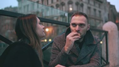 Genç adam ve kadın, iki arkadaş akşam ve sandviç yeme köprüde oturma. Çift var bir ara.