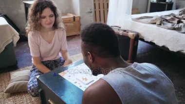 Kadın zar atar ve kart alır. Adam elini alır ve bir parmak çizer. Çok ırklı çift yaban domuzu oyunu oynar.