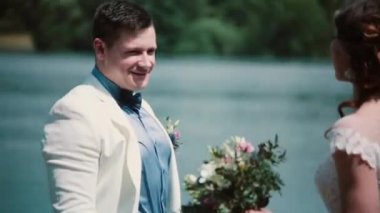 Düğün günü. Güzel çift payı bir iskele üzerinde mutlu an duran sarılma. Düğün kıyafeti, buket