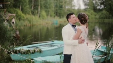 Mavi gemilerde bu güzel yerde bir gölet yakınındaki güzel aşık öp. Gelin ve Damat Düğün günü tadını çıkarın