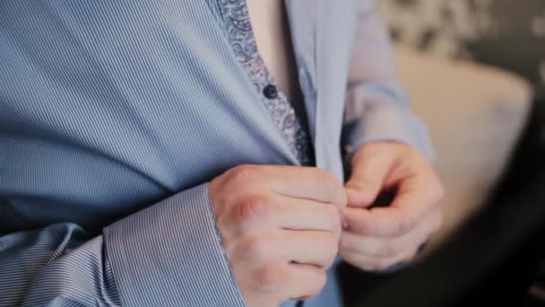 男性のクローズ アップ ビュー手ボタン ストライプ シャツ。新郎結婚式の準備彼のスーツを入れての朝. — ストック動画