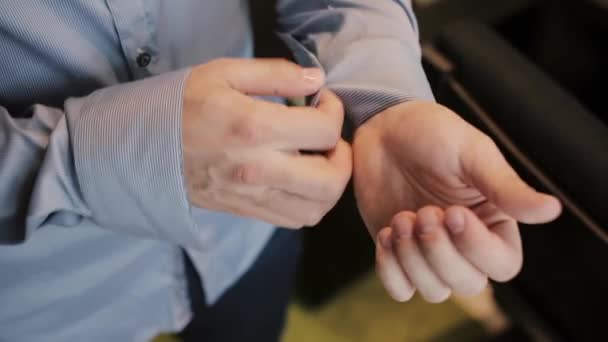 Vista de cerca de las manos masculinas jóvenes vistiéndose por la mañana. Los botones de hombre los puños en la camisa, preparándose para el trabajo . — Vídeo de stock