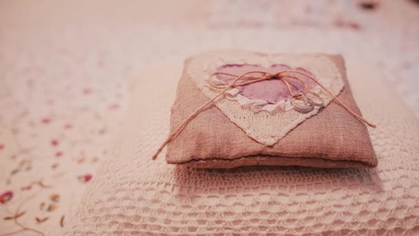 Two wedding rings on a little pillow. Preparation for a ceremony, details of wedding in rustic style. Slider right. — Stock Video