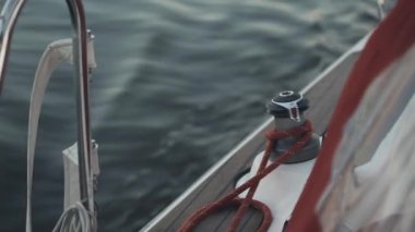 Yakın çekim görünümünü yelkenli yönetim kurulu. Dalgalar sıçramasına White Yat. Palamar başının etrafında sabitleme ip.