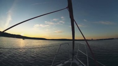 Yelkenli burun kısmının yakından görünümü. Günbatımı güzel su manzaraya. Dalgalar sıçramasına yat.