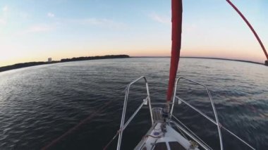 Yakın çekim vie burun yelkenli parçası su gider. Rüzgarda güneşli bir günde açık denizde günbatımı üzerinde yelken.