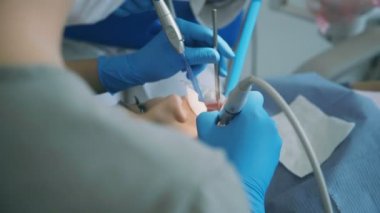 Genç kadın diş hekimi ziyaret etti. Doktor Diş hemşire ölçekleme ve diş parlatma bir hastayı tedavi ile.