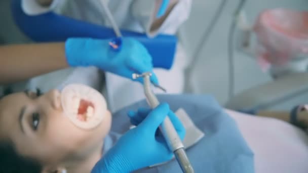 Il dentista prende lo strumento dentale e si rivolge al paziente. Medico con infermiera fare pulizia igienica e lucidatura dei denti . — Video Stock