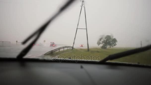 Limpiaparabrisas trabajando bajo la lluvia en un parabrisas. Vista de una carretera con coches . — Vídeo de stock