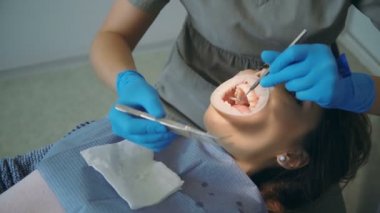 Genç kadın diş sandalye, diş hekimi temizlik ve Lehçe yalan dişlerini. Doktor ile hemşire almak optradam.