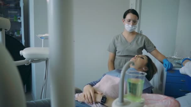 牙科治疗，医生结束抬起牙科椅。年轻女性来访牙医检查口腔. — 图库视频影像