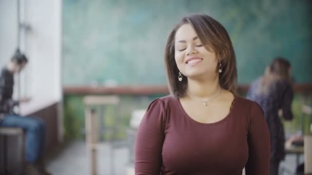 Retrato de la joven mujer africana hermosa en la oficina ocupada sonriendo. Mujer mirando a la cámara y dar un beso de aire . — Vídeos de Stock