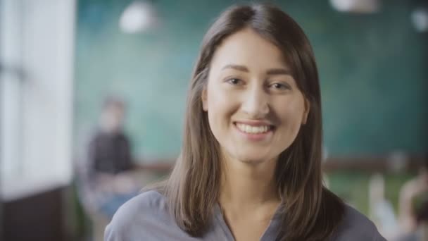 Retrato de atraente mulher de negócios asiática no escritório loft. Trabalhadora bem sucedida vira, olha em volta e sorrindo . — Vídeo de Stock