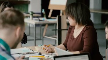 Yaratıcı karışık yarış ekibi trendy coworking uzayda gülüyor. Şirket haberleri konuşan kadın takım lideri.