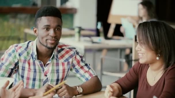 Grupo de jóvenes de raza mixta de personas tienen una conversación en la oficina moderna. Equipo creativo en una pequeña empresa de nueva creación . — Vídeo de stock