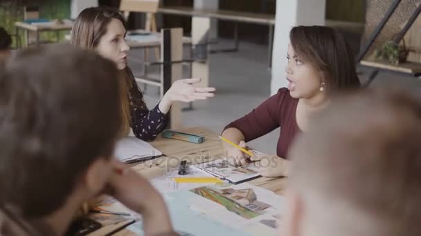 Jeune femme chef d'équipe parlant avec un petit groupe multiracial de personnes. Réunion d'affaires de la start-up au bureau .