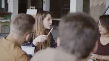 Ekibiyle yön veren genç kadın Yöneticisi. Çok ırklı bir grup insan sabah çatı ofiste planlama.