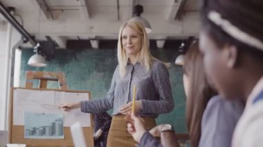 Modern ofisindeki karışık yarış takımının iş görüşmesi. Finansal verileri çalışma sonuçlarının özetliyor sunmak kadın Yöneticisi.