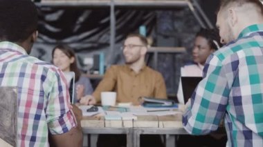 Genç yaratıcı ekibi modern ofiste çalışıyor. Karışık yarış grup iş görüşmesi. Afrika ve beyaz adam yumruk tebrik