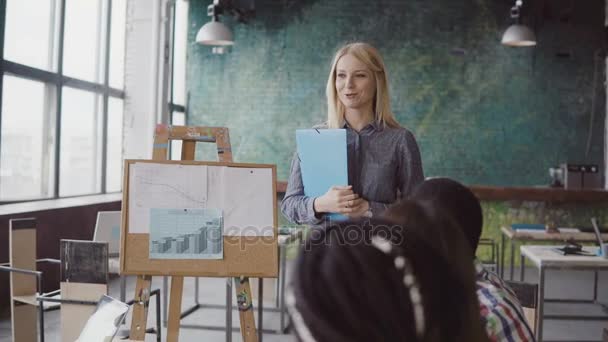 Reunión del equipo multiétnico de jóvenes empresarios. Hermosa mujer gerente presentando datos financieros a grupo de personas . — Vídeos de Stock