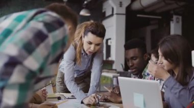 Karışık yarış bir grup insan, evin model üzerinde bir marker ile yazar ile konuşurken esmer kadın takım lideri.