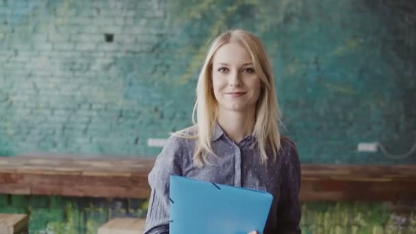 Retrato de mulher de negócios loira bonita bem sucedida no espaço de co-trabalho loft. Feminino segura o documento, sorrindo . — Vídeo de Stock