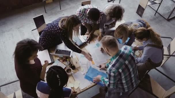 Reunião de negócios no escritório moderno. Visão superior do grupo multirracial de pessoas que trabalham perto da mesa juntas . — Vídeo de Stock