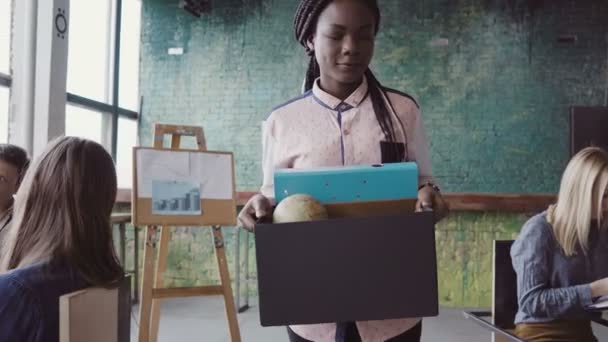 Νεαρή Αφρικανή γυναίκα να πάρει απολύθηκε από την εργασία. Γυναίκα περπατά μέσα από το γραφείο, μεταφέρουν κουτί με τα προσωπικά αντικείμενα. — Αρχείο Βίντεο