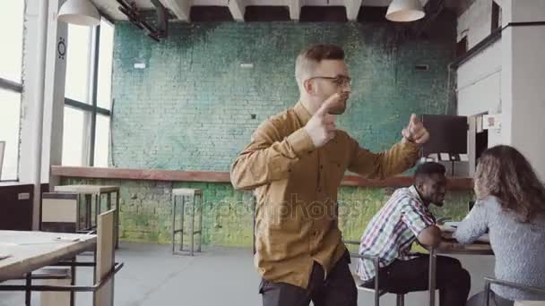 Beau jeune homme d'affaires faisant danse de la victoire sur la réussite. Homme heureux au bureau moderne à la mode .