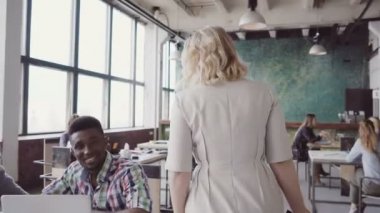 Güzel sarışın kadın takım lideri ofisine yürümek, çalışan çalışmalarını denetler, meslektaşım için yön verir