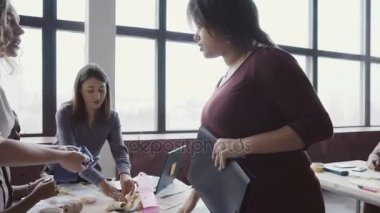 Modern ofis ve denetimleri bir çalışmayla çalışanın yürüyen genç Afrika takım lideri. Erkek kumaş örnekleri görünüyor.