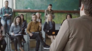 Gençler grup önünde duran ve konuşan genç iş adamı. Modern ofis, iş toplantısında Semineri.