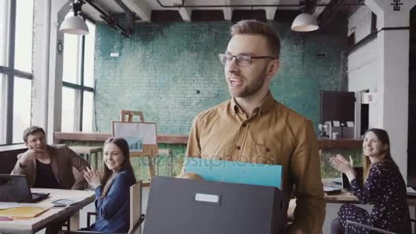 Beau homme récemment embauché à la société viennent dans un nouveau bureau. Boîte de maintien pour homme avec effets personnels, accueil avec personnes .