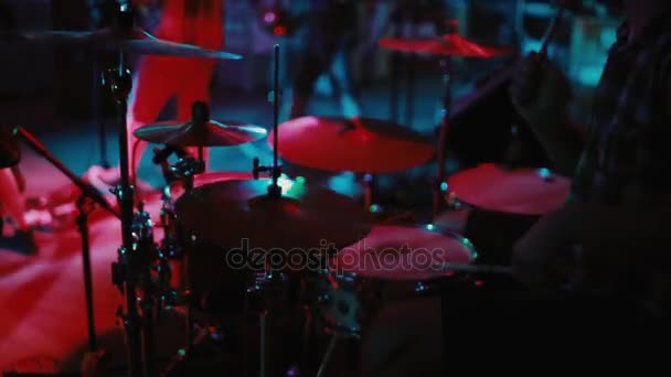 Vista de cerca de las obras de batería en el escenario. Banda de rock en un club nocturno o baile. El hombre usa un instrumento musical . — Vídeos de Stock