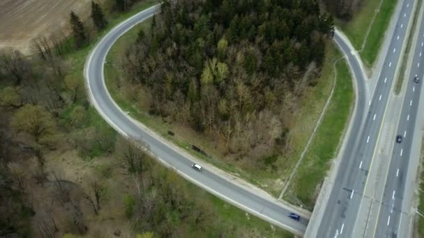Luchtfoto drone zicht op de rijbaan verkeer platteland in de buurt van het groene woud. Auto's rijden door middel van de vork. — Stockvideo