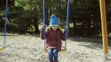 Salıncak üzerinde sevimli küçük kız. Güzel çocuk eğlenceli dışında bahçesi var. Erkek gelin elbiseleri, lastik çizmeler