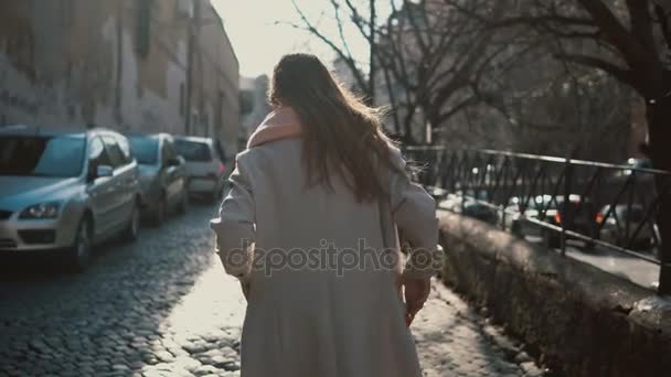 単独で市内中心部を歩いて髪の長い若い女性の背面します。道路の近く女性に行くと夢. — ストック動画