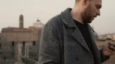 Genç çekici işadamı ılık bahar günü dışında smartphone kullanın. Yakışıklı erkek arkadaşları ile sohbet.