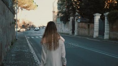 Arkadan görünüşü genç bayan yalnız şehir merkezine yürüme. Yola yakın gidiş uzun saçlı erkek gün zevk.