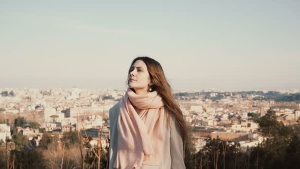 Portret van jonge mooie vrouw te wachten iemand tegen het panorama van Roma, Italië. Aantrekkelijke vrouw geniet van de dag. — Stockvideo