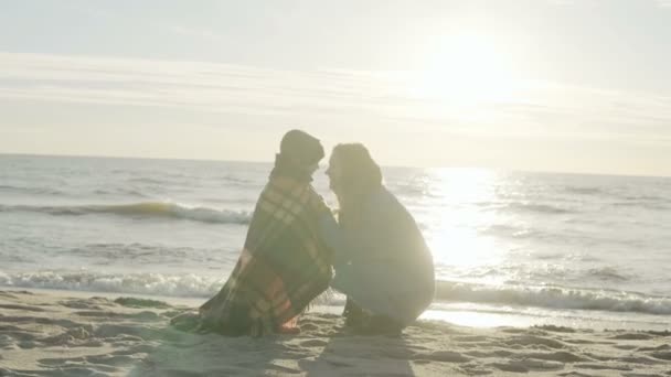 Sød lille dreng og hans unge mor tilbringer tid sammen på kysten af havet. Søn kysser kvinde på solrig strand . – Stock-video