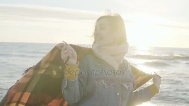 Genç güzel kadın ile ekose deniz kıyısında kadar eller yükseltir. Mutlu erkek sahilde güneşin tadını.