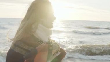 Mutlu genç çekici kadın kamera denizin kıyısında gülümseyen portresi. Ekose ile eller erkek yükseltir.