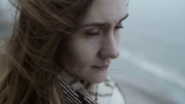Portrét mladé zamyšlená žena stojící poblíž vody a hledá dálky. Zasněný a smutná žena s vlající vlasy. — Stock video